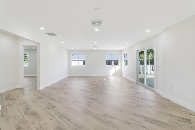 unfurnished room featuring light wood finished floors, plenty of natural light, recessed lighting, and baseboards