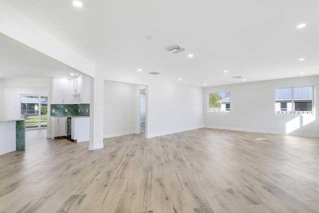 unfurnished living room with recessed lighting, baseboards, visible vents, and light wood finished floors