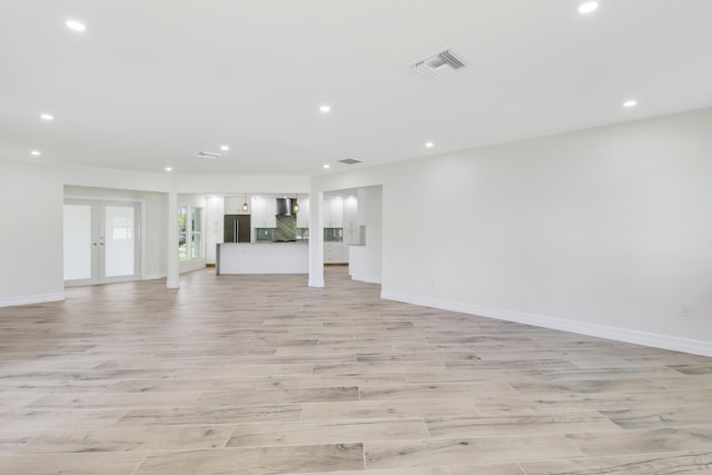 unfurnished living room with light wood-type flooring, recessed lighting, visible vents, and baseboards