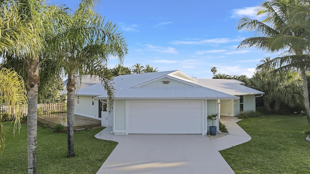 ranch-style home with fence, metal roof, a garage, driveway, and a front yard