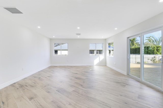 empty room with light wood-type flooring, visible vents, baseboards, and recessed lighting