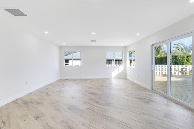 empty room featuring light wood-type flooring, visible vents, and recessed lighting