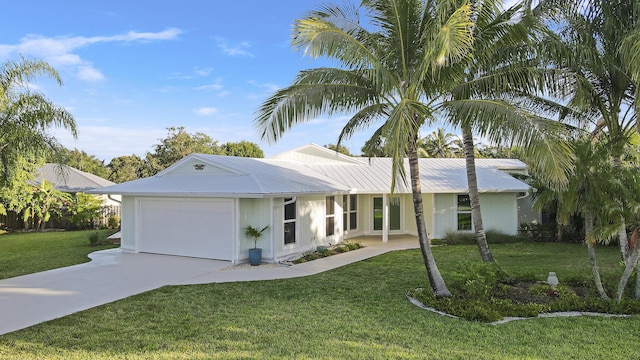 ranch-style home featuring a front lawn, concrete driveway, an attached garage, and metal roof