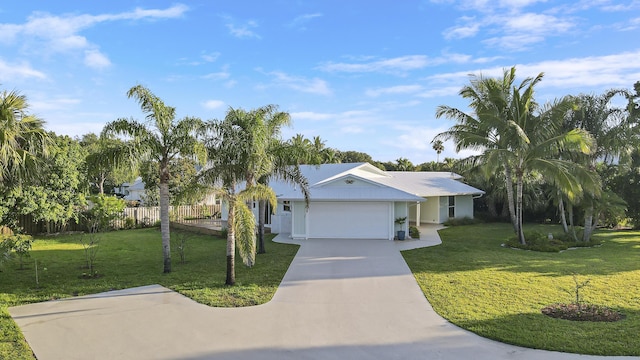 ranch-style home featuring driveway, fence, a front yard, and a garage