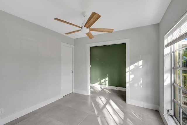 unfurnished room with light tile patterned flooring and ceiling fan