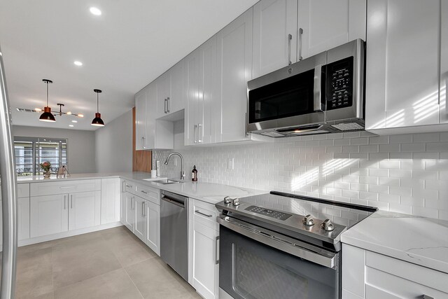 kitchen with pendant lighting, a kitchen bar, kitchen peninsula, and sink