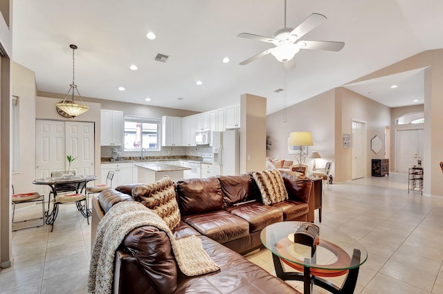 living room featuring ceiling fan, lofted ceiling, sink, and light tile patterned floors