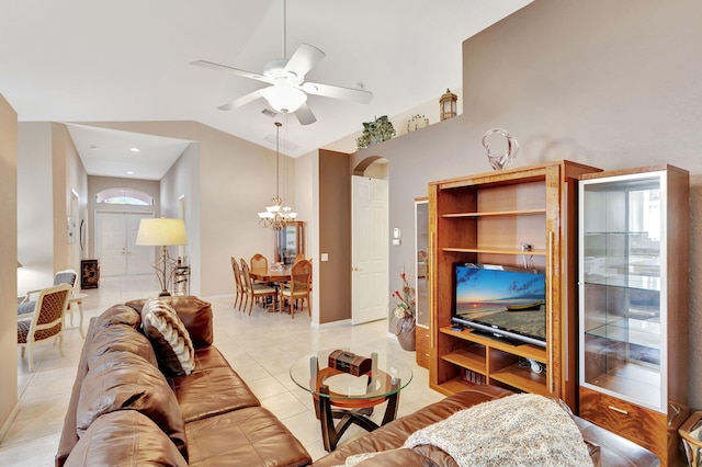 living room with vaulted ceiling, ceiling fan with notable chandelier, and light tile patterned floors