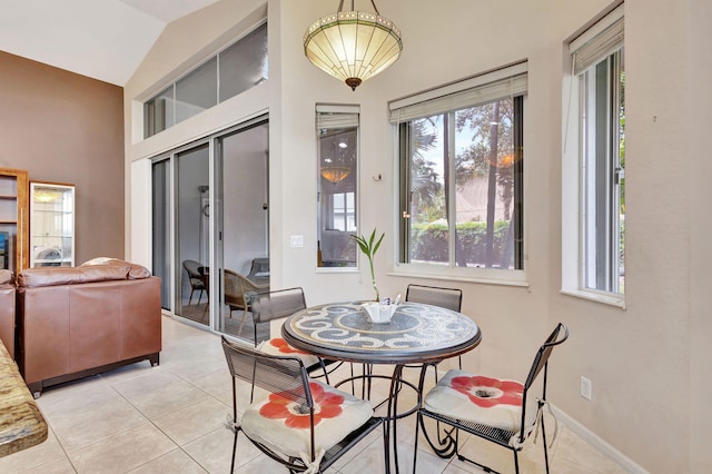 tiled dining space with lofted ceiling