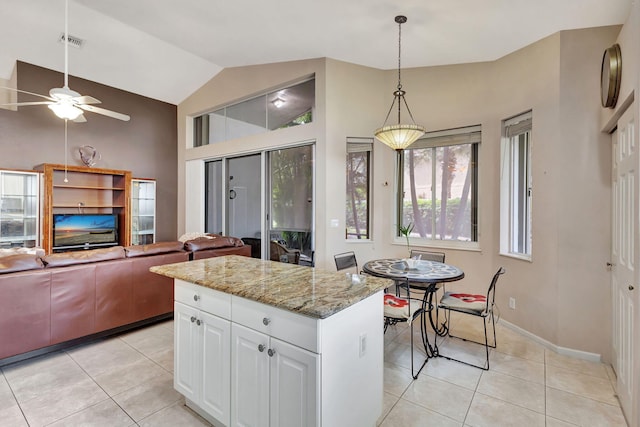 kitchen with white cabinetry, light stone counters, decorative light fixtures, and light tile patterned flooring