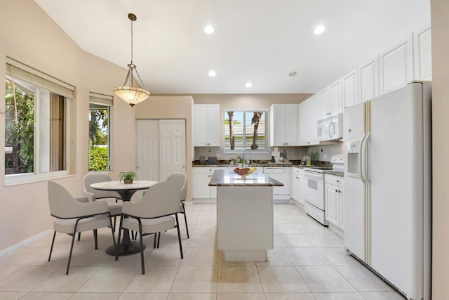 8430 Marsala Way, Boynton Beach, FL 33472 - kitchen with white appliances, a center island, decorative backsplash, white cabinets, and hanging light fixtures