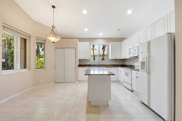8430 Marsala Way, Boynton Beach, FL 33472 - kitchen featuring white appliances, a kitchen island, white cabinets, light tile patterned floors, and decorative backsplash