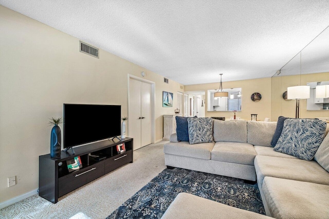 carpeted living room featuring a textured ceiling