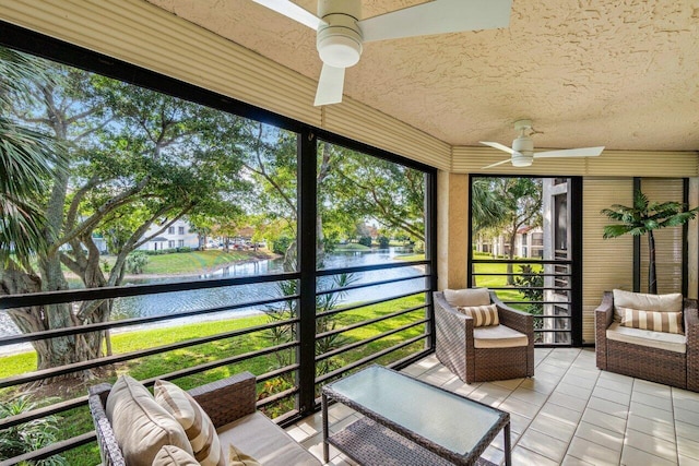 unfurnished sunroom with ceiling fan and a water view