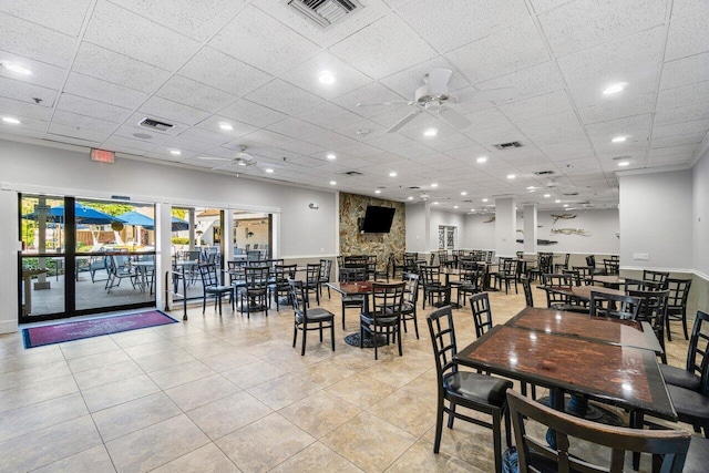 dining room featuring light tile patterned flooring, a drop ceiling, and ceiling fan