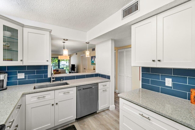 kitchen featuring decorative light fixtures, sink, white cabinets, stainless steel dishwasher, and light hardwood / wood-style flooring