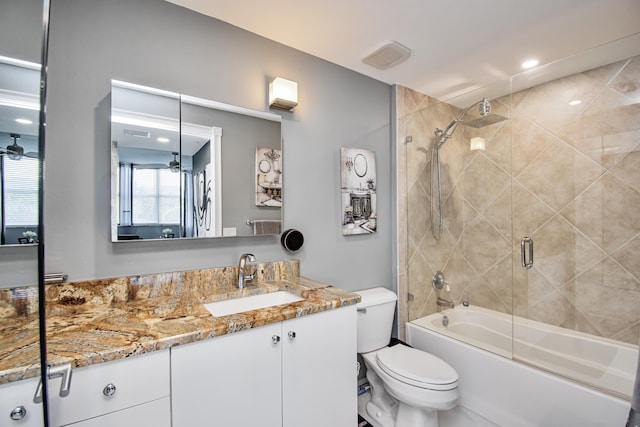 full bathroom with vanity, ceiling fan, enclosed tub / shower combo, and toilet