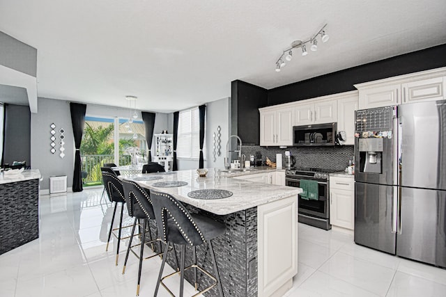 kitchen with tasteful backsplash, white cabinetry, sink, a kitchen bar, and stainless steel appliances