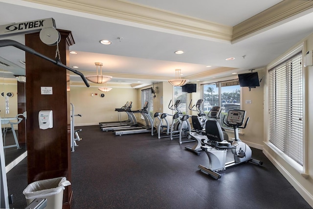 gym featuring ornamental molding and a tray ceiling