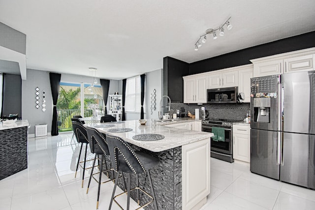 804 E Windward Way Unit 623, Lantana, FL 33462 - kitchen with stainless steel appliances, backsplash, light stone counters, a kitchen breakfast bar, and light marble finish flooring