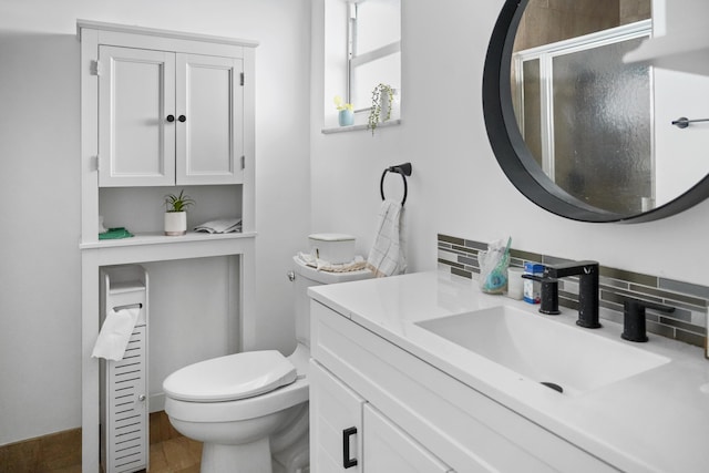 bathroom with tasteful backsplash, vanity, toilet, and an enclosed shower