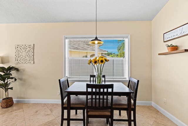 tiled dining area featuring a textured ceiling