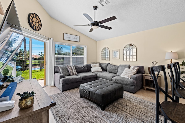 living room with light tile patterned flooring, lofted ceiling, ceiling fan, a water view, and a textured ceiling