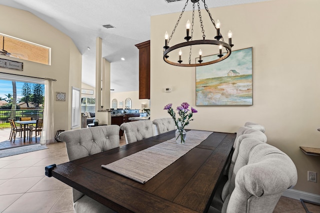 dining room with lofted ceiling, ceiling fan with notable chandelier, and light tile patterned floors