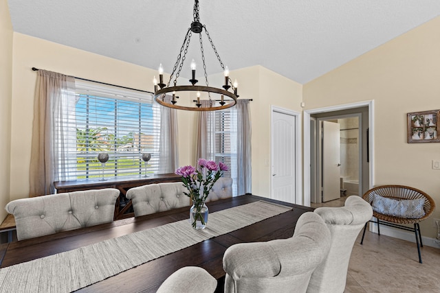 dining space with a wealth of natural light, vaulted ceiling, a chandelier, and light tile patterned flooring