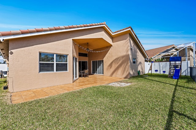 rear view of property with a yard and a patio area