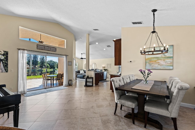 tiled dining room featuring lofted ceiling, a textured ceiling, and an inviting chandelier