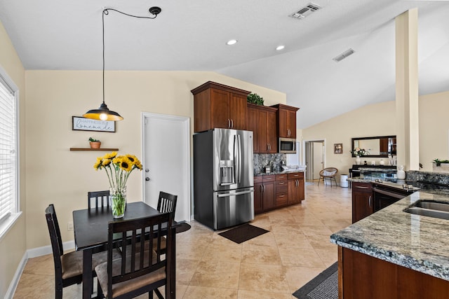 kitchen with lofted ceiling, tasteful backsplash, plenty of natural light, and appliances with stainless steel finishes