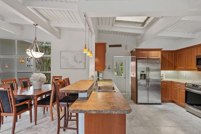 kitchen featuring pendant lighting, stainless steel appliances, kitchen peninsula, and a kitchen bar