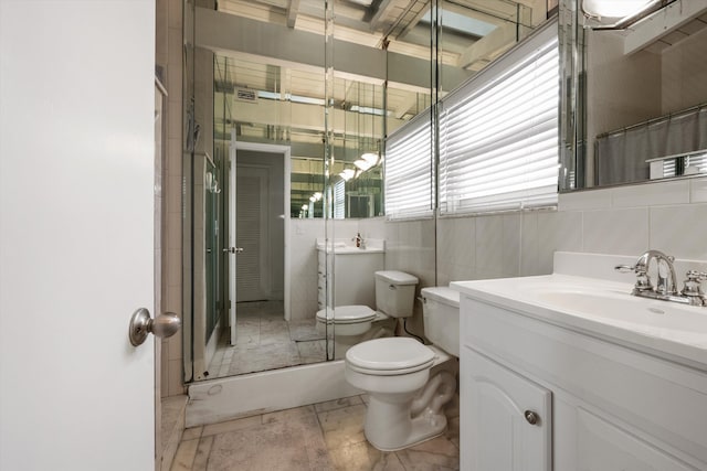 bathroom with vanity, toilet, curtained shower, and tile walls