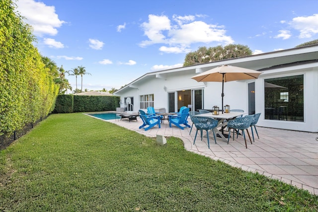 back of property featuring a fenced in pool, a yard, and a patio