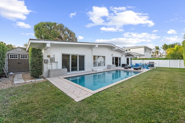 rear view of house featuring a storage shed, a yard, an outdoor hangout area, a fenced in pool, and a patio area