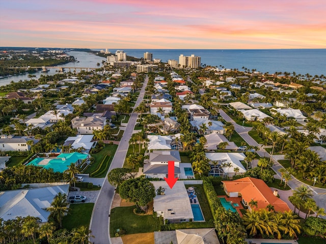 aerial view at dusk featuring a water view