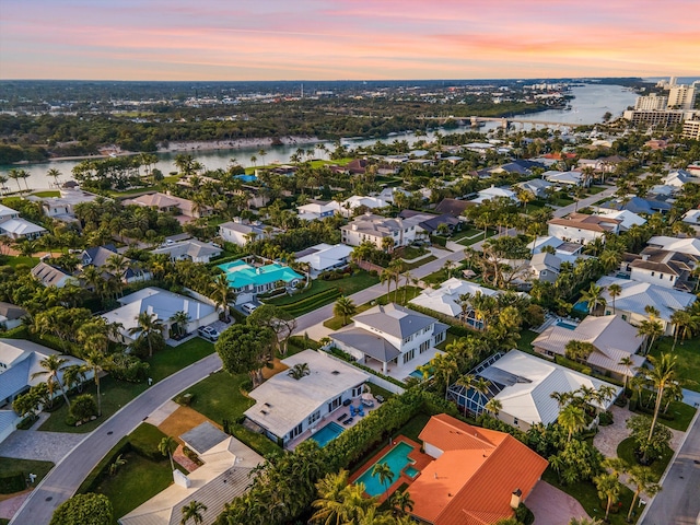 aerial view at dusk featuring a water view