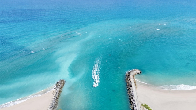 birds eye view of property with a water view and a beach view