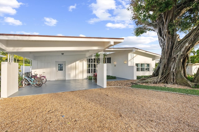 back of house featuring a carport