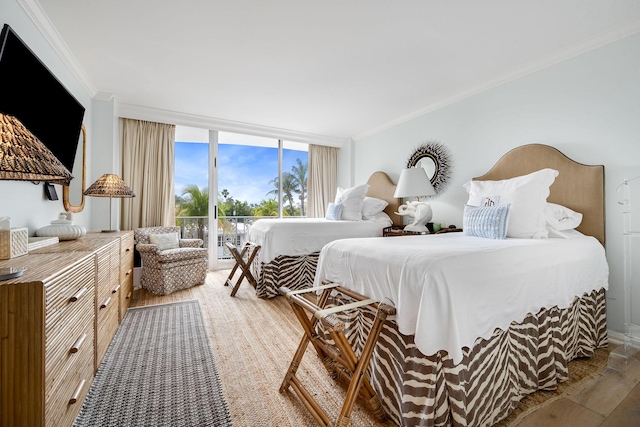 bedroom with expansive windows, access to outside, ornamental molding, and wood finished floors