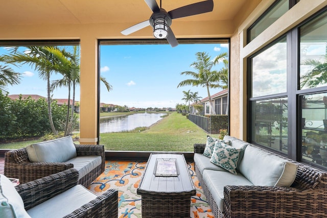 sunroom / solarium with a water view, ceiling fan, and a healthy amount of sunlight