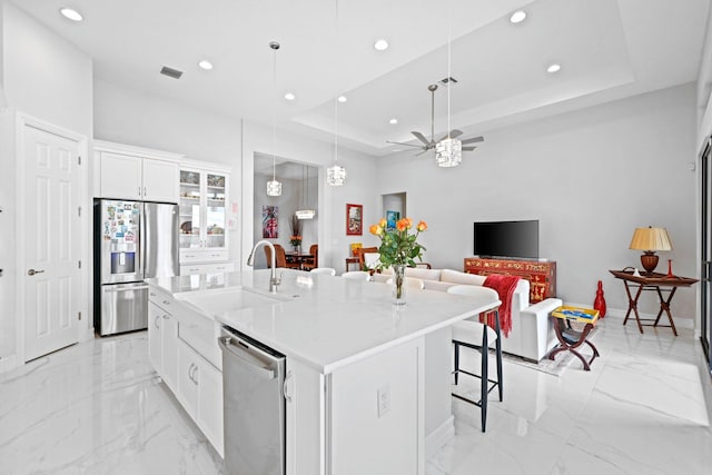 kitchen featuring white cabinetry, stainless steel appliances, sink, and a kitchen island with sink