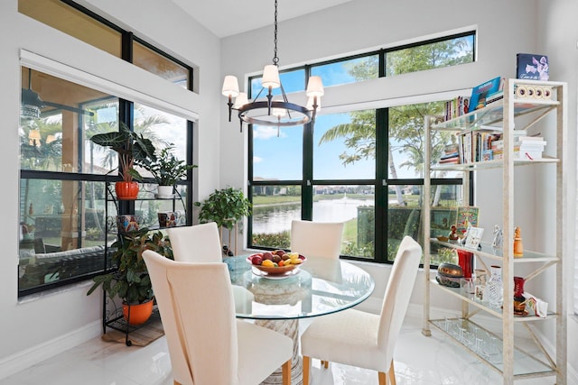 dining space featuring plenty of natural light, a chandelier, and a water view