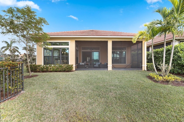 rear view of property featuring a lawn and a sunroom