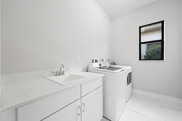 washroom with cabinets, separate washer and dryer, and sink