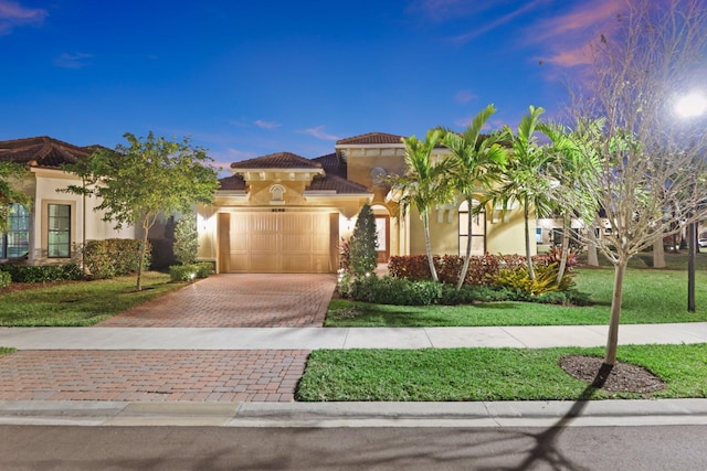 mediterranean / spanish house with a yard and a garage