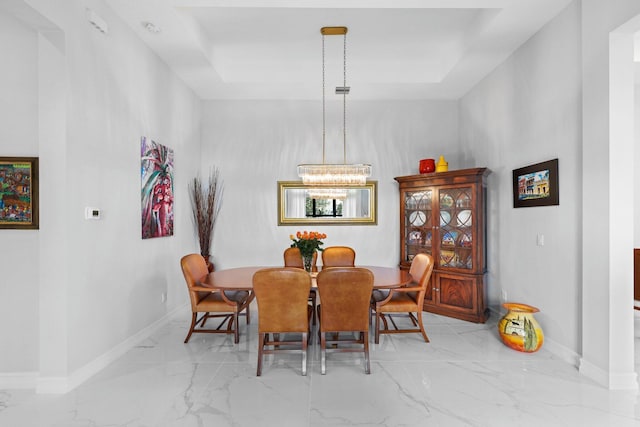 dining space featuring a raised ceiling