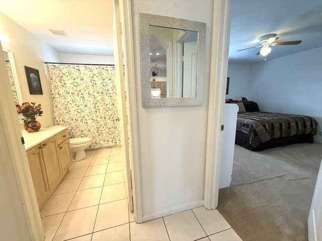 bathroom with ceiling fan, vanity, tile patterned floors, toilet, and walk in shower