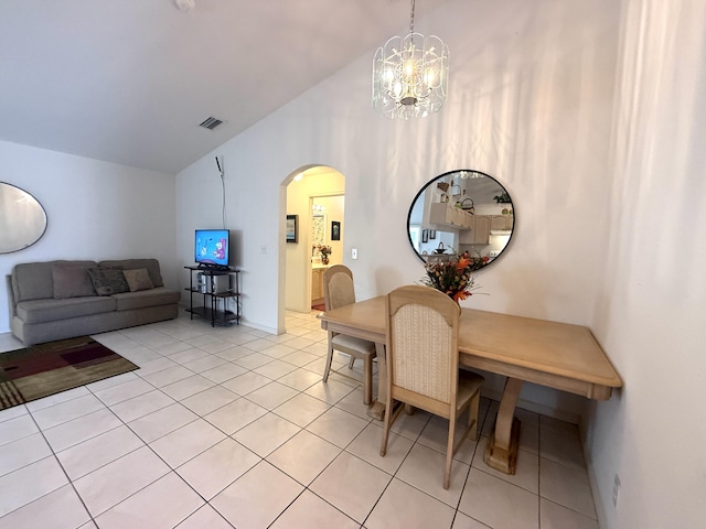 dining room with lofted ceiling, light tile patterned floors, and an inviting chandelier